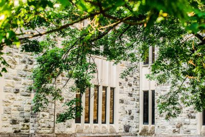 A building clad in Hokie Stone with a tree branch in front of it