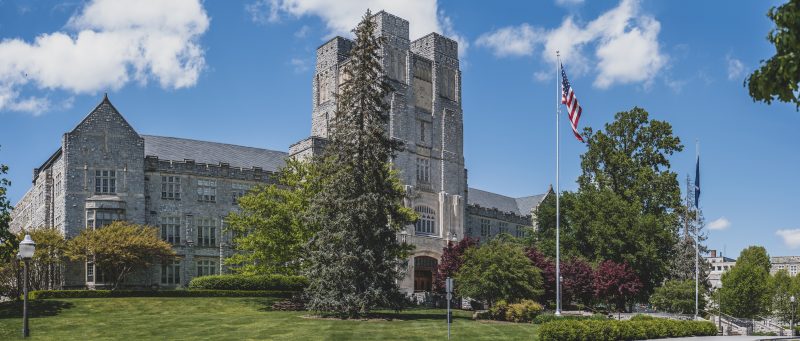 Grey Hokie Stone Burruss Hall surrounded by green trees on a sunny day